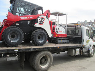 Takeuchi skid steer on flatbed truck